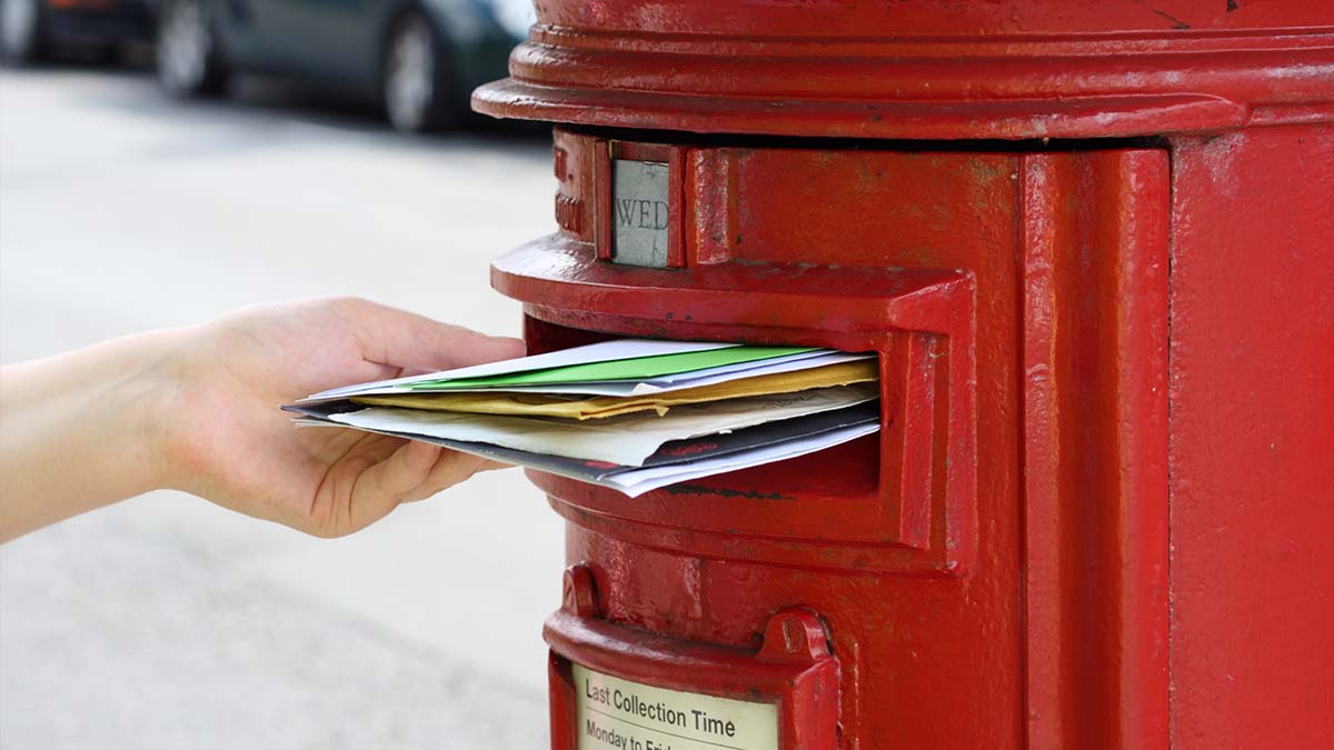 Stuffed mail in Royal Mail postbox.