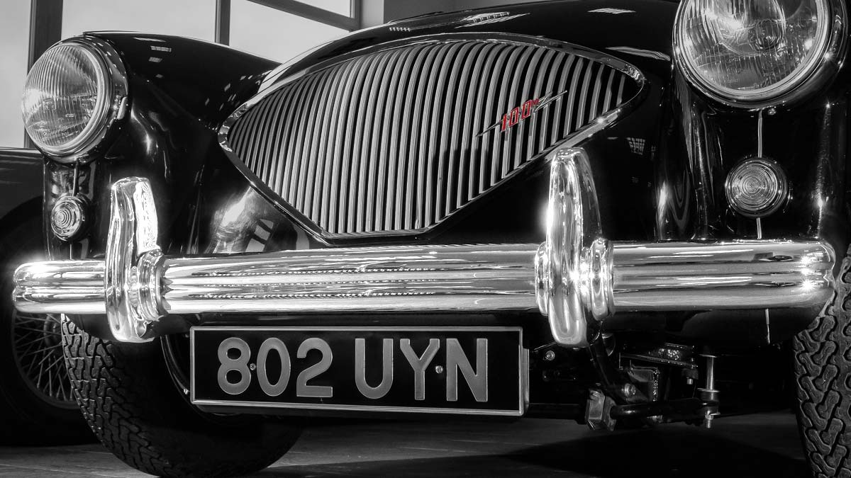 Black Austin Healey 100 with highlighted chrome front bumper