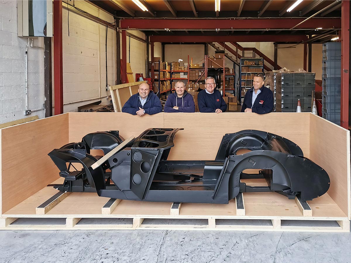 A H Spares Management team with an Austin Healey BT7 centre change inner body assembly at A H Spares in Southam, Warwickshire.