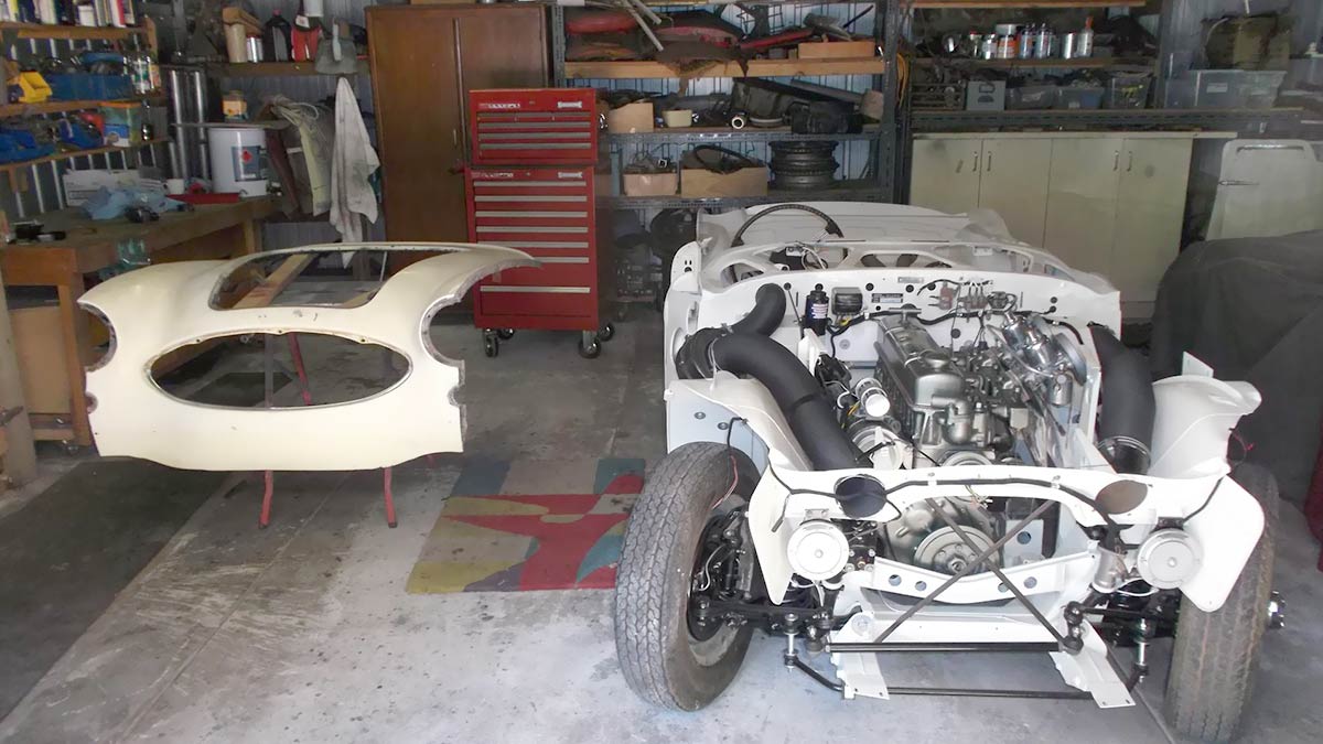 Austin Healey front shroud painted white next to an Austin Healey 100/6 without any body panels.