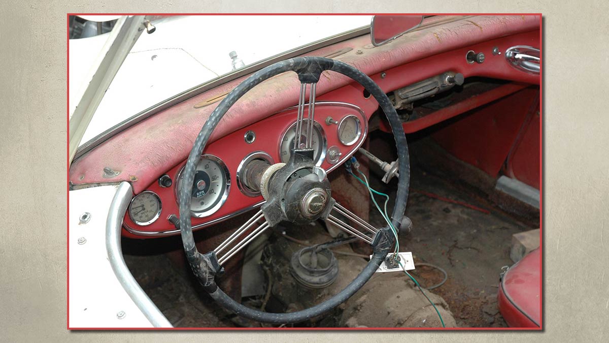 Dashboard and steering wheel of an unrestored Austin Healey 100/6.