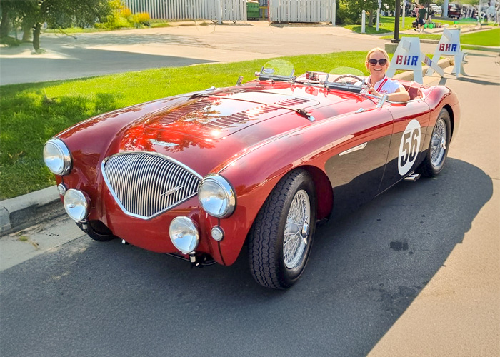 Rebecca Kemsley driving a red and black Austin Healey 100M