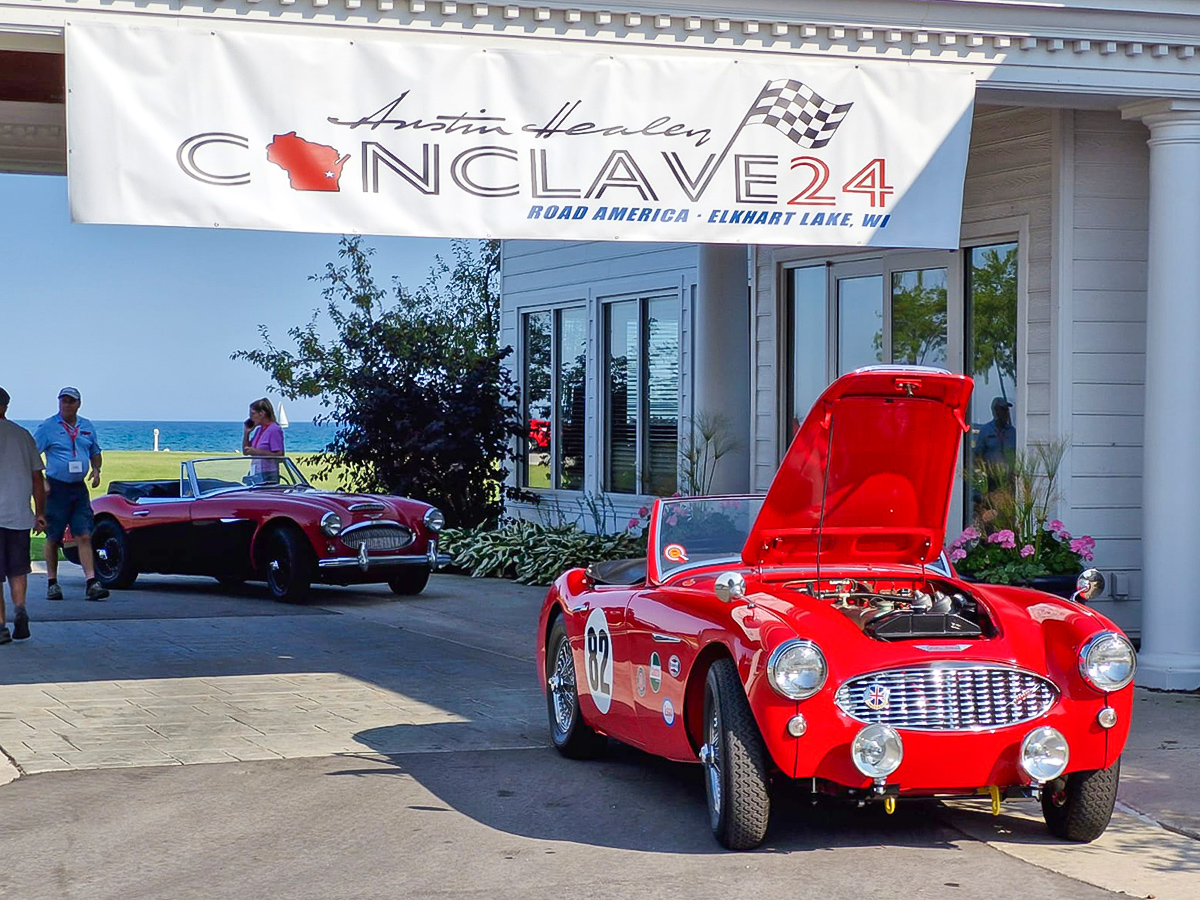 Red Austin Healey 100/6 British sports car parked underneath the Conclave 24, banner at the Blue Harbor Resort and Conference Center in WI, USA