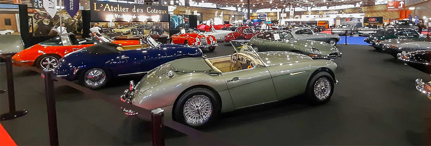 L’Atelier des Coteaux stand at Époqu’Auto Lyon 2025 featuring Austin Healey, Jaguar, and other classic sports cars.