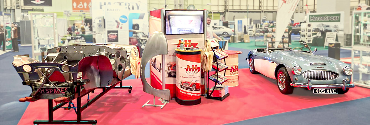 A H Spares stand at the 2025 NEC Classic Motor Show Birmingham featuring an Austin Healey BT7, chassis display, and body panels showcasing high-quality restoration parts.