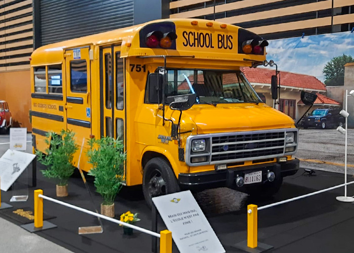 Restored yellow American school bus on display at Époqu’Auto Lyon 2025 classic car and vehicle exhibition.