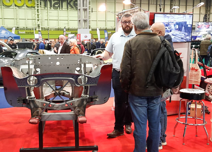 Visitors discussing Austin Healey chassis and panels with A H Spares team at the Classic Motor Show