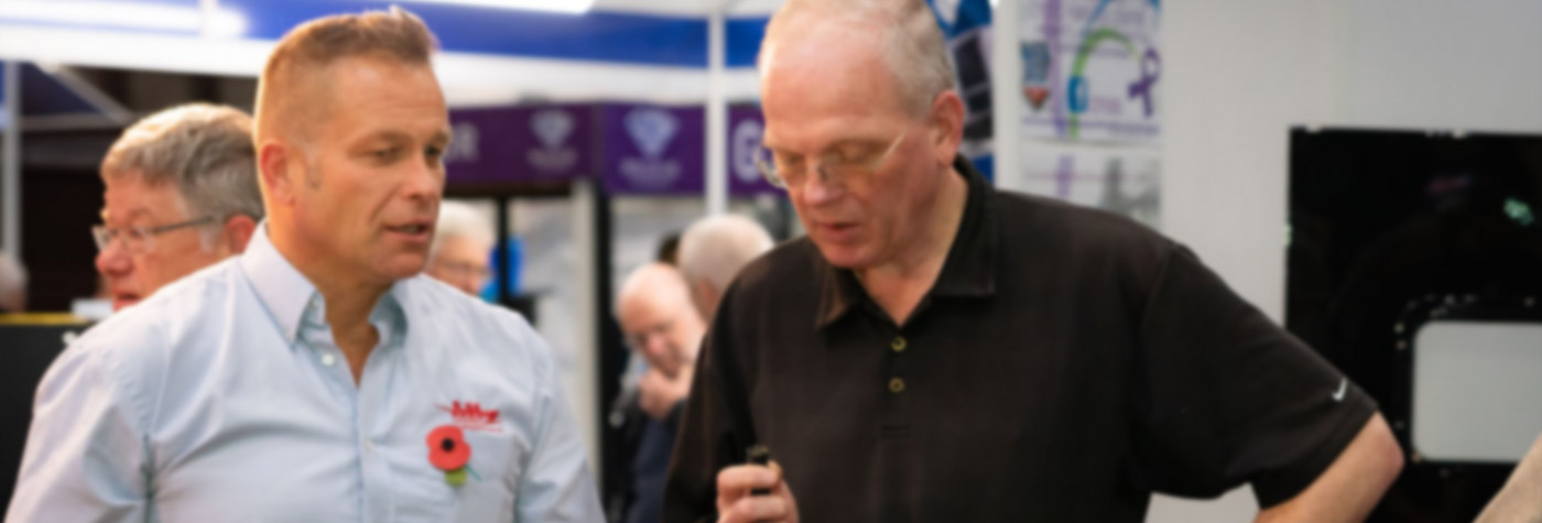 John Lee speaking with a visitor to the A H Spares exhibit at the Classic Motor Show 2019