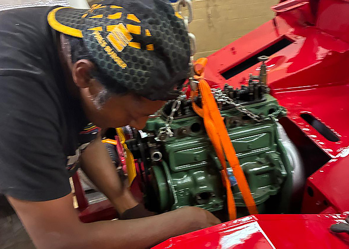 Alex installing a rebuilt A-Series engine into his Austin Healey Frogeye Sprite during restoration in Sweden.