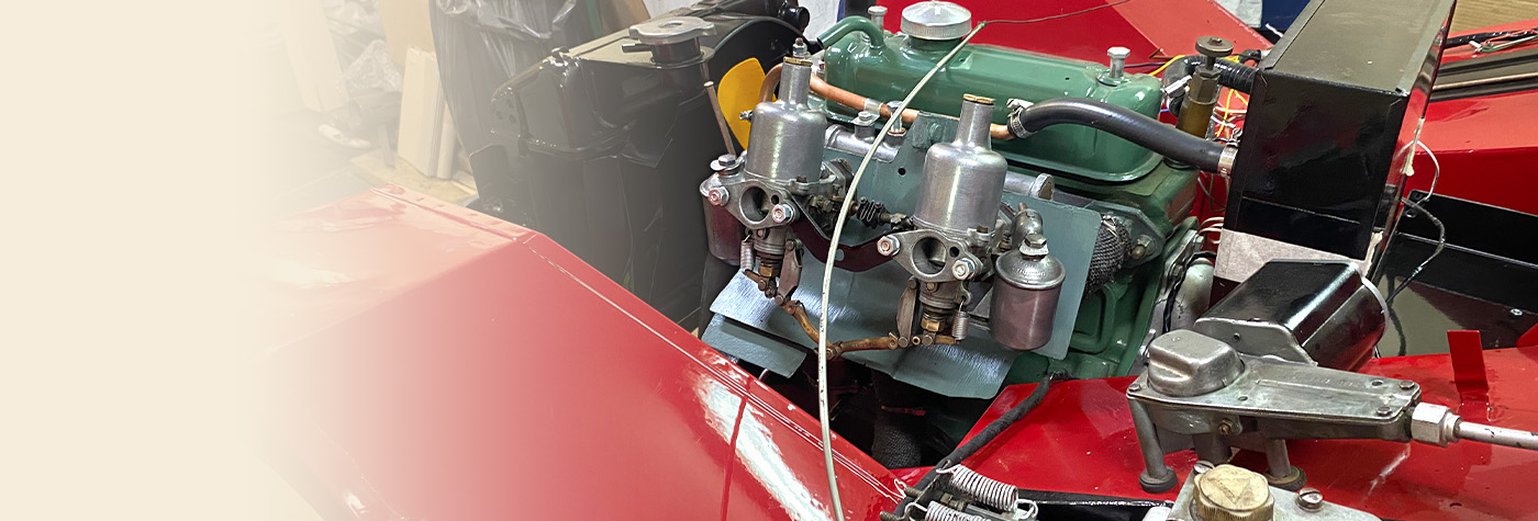 Close-up of rebuilt A-Series engine and twin SU carburettors installed in a restored red Frogeye Sprite.