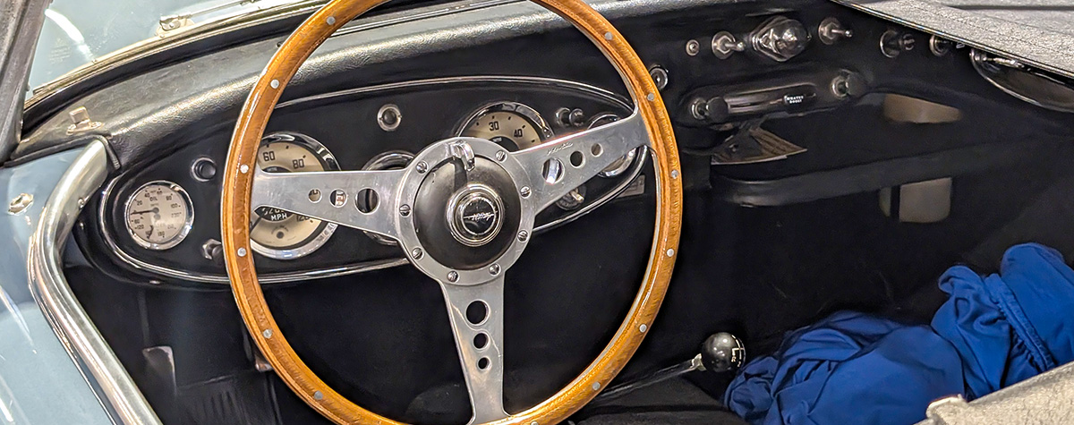 Austin Healey 3000 cockpit showing original wooden steering wheel and Smiths gauges