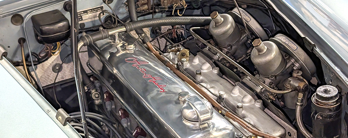 Austin Healey 3000 engine bay with twin SU carburettors and polished rocker cover