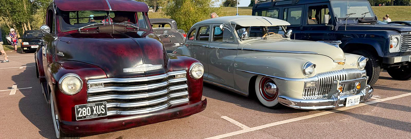 1950s Chevrolet pickup and post-war American sedan at the Gaydon Gathering, British Motor Museum—American classics with chrome grilles and whitewall tyres.