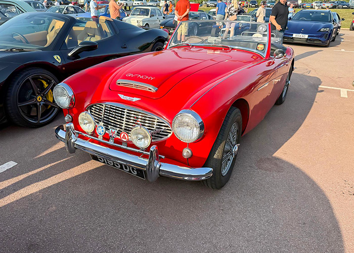 Classic red Austin-Healey sports car with badge bar and spotlights at the British Motor Museum’s Gaydon Gathering.
