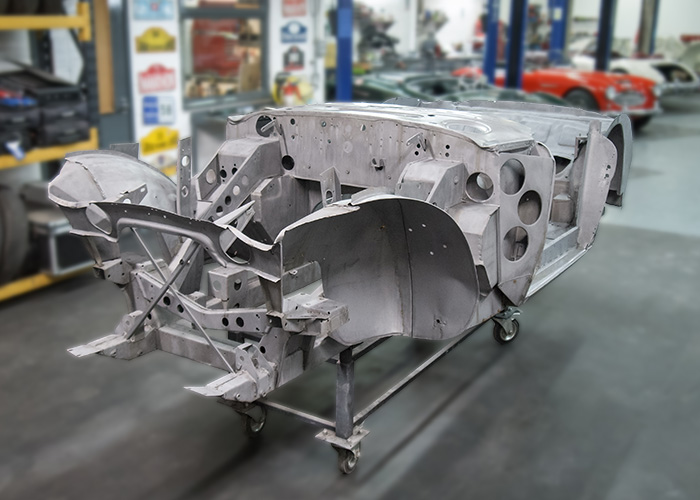 Bare Austin Healey 3000 BJ8 inner body shell on workshop frame before painting.