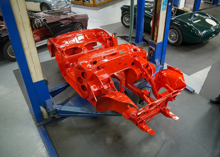 Freshly painted Austin Healey 3000 BJ8 chassis in bright red at JME Healeys restoration workshop.