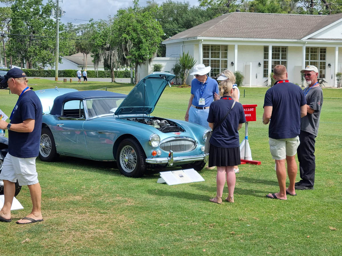 Austin Healey club members speaking with John Lee and Rebecca Kemsley from A H Spares