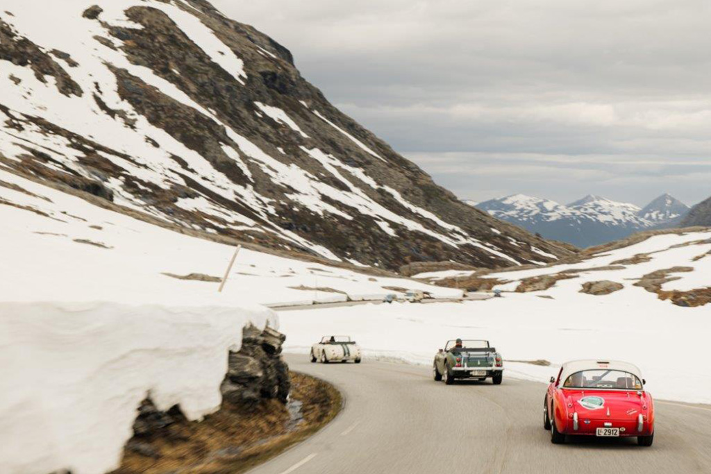 Three Austin Healeys driving through snowy mountains in Norway