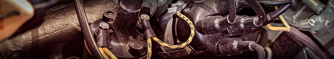 Detailed view of Austin Healey 100M ignition system with distributor and leads, illustrating classic 25D4 distributor components for Le Mans tuning.