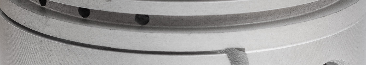 Close-up of machined piston for Austin Healey 100M engine, highlighting high-quality finish and engineering accuracy for 100M performance builds.