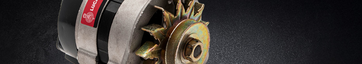 Close-up banner image of a Lucas Classic alternator, showing the gold-coloured cooling fan, pulley nut, and red Lucas label against a textured dark background.