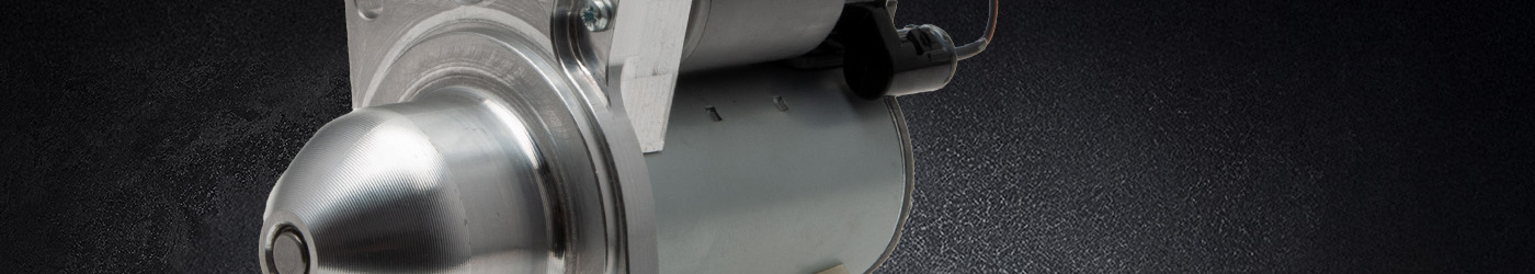 Close-up banner image of a Lucas Classic Sprite starter motor, highlighting the polished aluminium nose cone, cylindrical motor body, and wiring detail against a dark textured background.