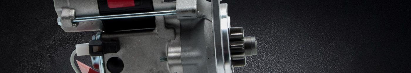 Close-up banner image of a Lucas Classic starter motor, highlighting the pinion gear, aluminium housing, and red Lucas label against a dark textured background.