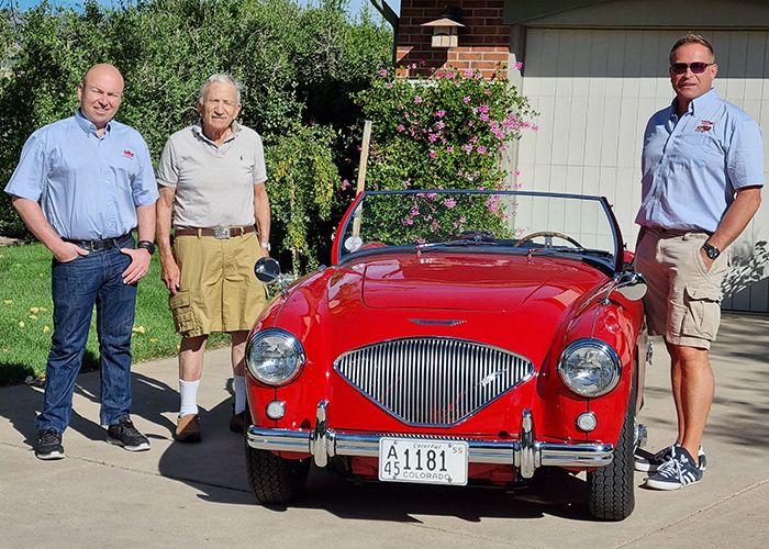 Jon Hill, Roger Moment, and John Lee standing next to Roger Moment's Austin Healey 100 BN1