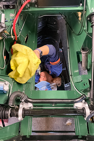 Cari Kalapis working around her Austin Healey Sprite after the engine had been removed again