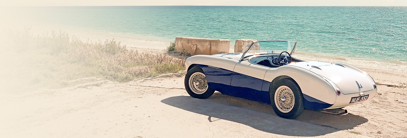 Graham Foster's two-tone Austin Healey 100/4 parked beside the sea in Greece