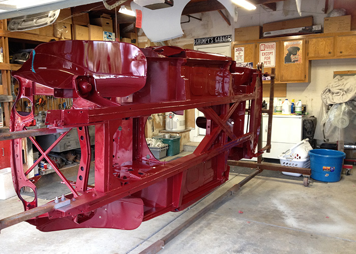 Painted monocoque framework of Pete Davies' Austin Healey 3000 mounted on a rotating restoration frame