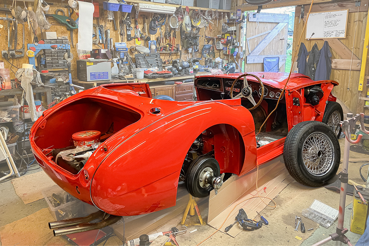 Freshly painted Austin Healey 3000 body shell in red during Peter Hunt's home paint process